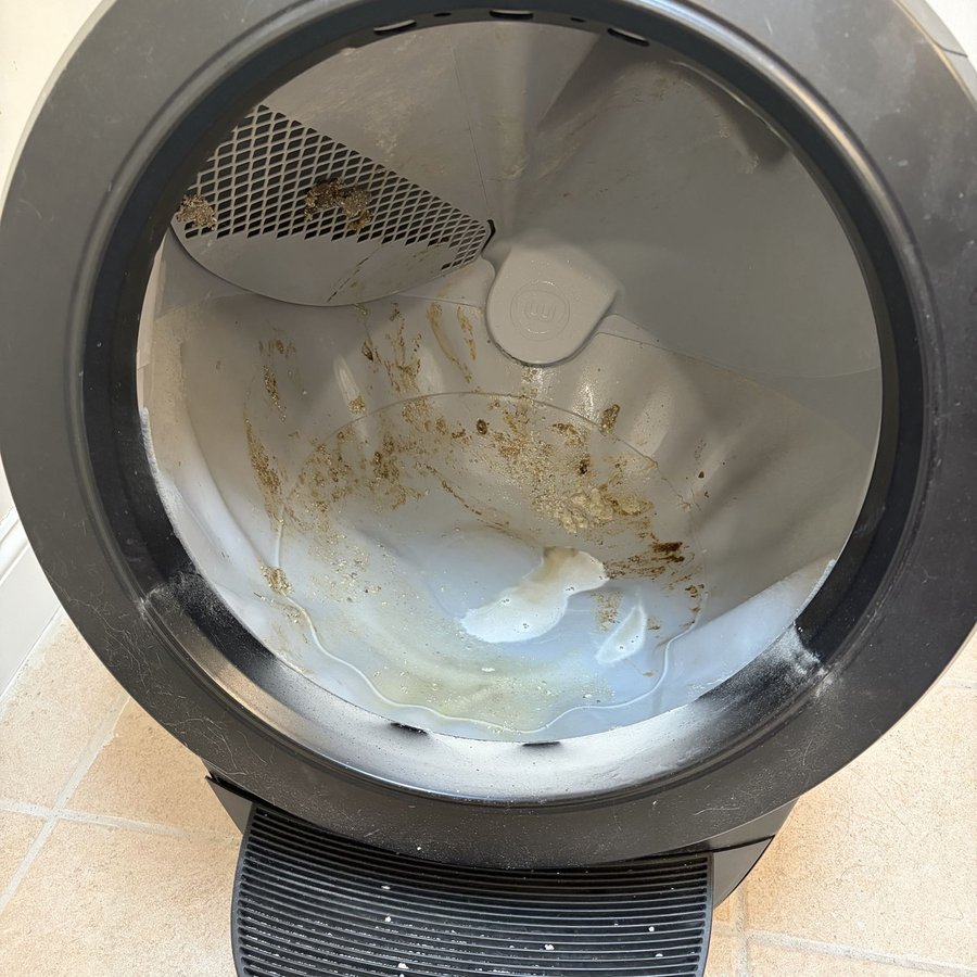 Automatic litter box globe with residue before a LitterReserve deep clean